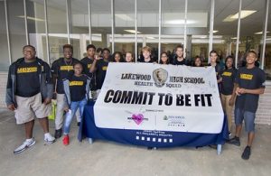 group-of-high-school-students-stands-with-commit-to-be-fit-banner