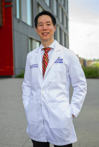 Wilmer doctor stands wearing white coat outdoors