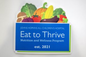 Eat to Thrive sign featuring colorful fruits and vegetables 