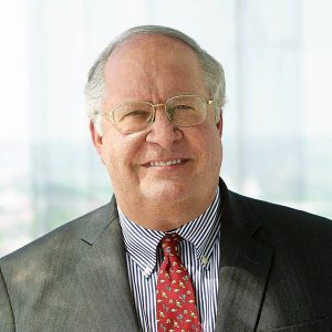 Donor to the Johns Hopkins Department of Physics and Astronomy William “Bill” Miller wears glasses, a striped shirt, red tie, and gray suit jacket.