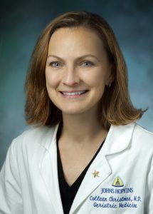 Rosemarie Hope Reid, M.D., Professor Colleen Christmas wearing a white Johns Hopkins medical coat.