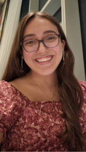 cty scholars program alumna venezia garza smiles in a red floral top, glasses, and long earrings