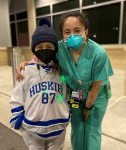 Howard County General Hospital emergency physician Jeanine Reyes-Bautista smiles with a member of the Howard Huskies youth hockey team