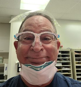 Rick Caporin, a nurse who participated in the Mindful Ethical Practice and Resilience Academy, smiles for the camera, wearing his personal protective equipment.