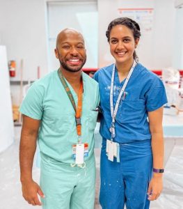 Hopkins orthopaedic surgery residents chris murdock and yesh parekh smile in blue scrubs