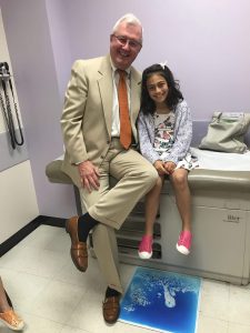 Hopkins bladder exstrophy patient evyn weiss and dr. john gearhart smile on a doctors table