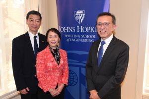 Yu Wu, Chaomei Chen, and Fadil Santosa stand by a Johns Hopkins Whiting School of Engineering banner