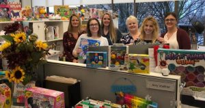 Surrounded by colorful toys and board games, Johns Hopkins Children’s Center volunteer Melissa Bissen smiles and stands with five other women.