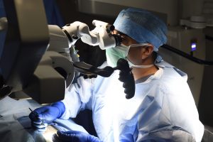 johns hopkins assistant professor of urology and male infertility specialist amin herati looks through a state of the art microscope during surgery