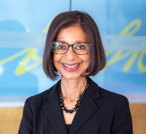 With chin-length dark hair, Wm. Carey Polk Carey Distinguished Professor Ritu Agarwal smiles and wears glasses and a black top, necklace and blazer.