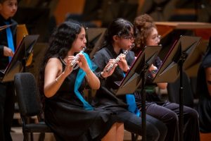 three flautists playing at the OrchKids 15th anniversary concert