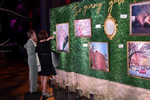 a group looks at art at the sibley young professionals board's sibley soiree