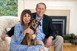 hopkins alum and donor mindy farber and husband john camp sit in their home with a rescue dog