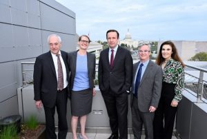 The advisory board is smiling outside the Hopkins Bloomberg Center in Washington, D.C. In the distance is the U.S. Capitol.