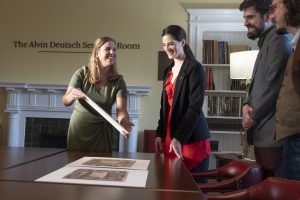 kelsey champgane shows ephemera to people at the virginia fox stern center