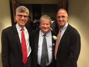 three johns hopkins alumni, who call themselves the friends of monroe, stand with monroe zeffert wearing suits and ties