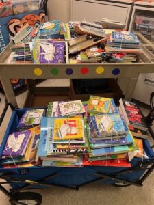 More than 350 children's books are sitting in a blue wagon at the Children's Center. The variety of books are tied together with a note from the Kramers.