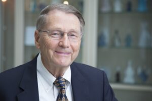 Johns Hopkins professor and physician Moody Wharam smiles and wears glasses, white shirt, tie and navy jacket