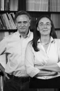 Nancy Madden is standing in front of the late Robert Slavin. The black and white image shows the researchers smiling in front of a bookcase.